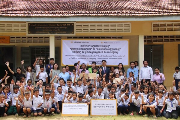 7일 캄보디아 프놈펜에서 진행된 기부 물품 전달식에서 KB국민카드 현지법인 KB대한특수은행 임직원들과 운롱깐초등학교 아이들이 기념촬영을 하고 있다. ⓒ KB국민카드